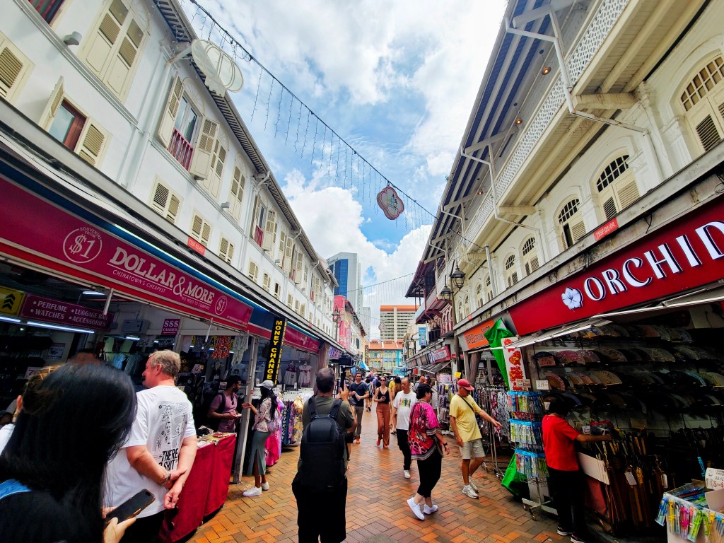Bustling Chinatown street in Singapore with red lanterns, shophouses,
