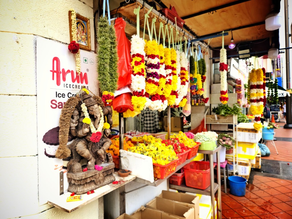 Colorful street in Little India Singapore with vibrant wall murals, shops, and Indian cultural motifs